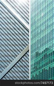 Closeup view of generic modern office skyscrapers ,high rise buildings with abstract geometry glass facades on a bright sunny day . Concepts of finances and economics background.