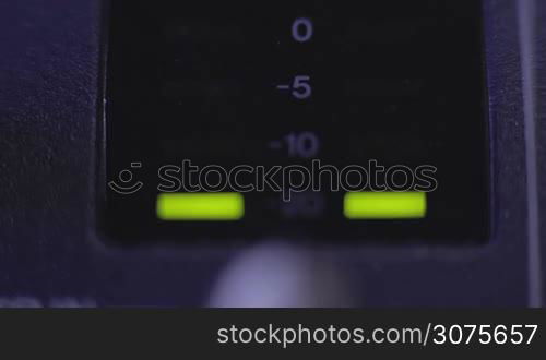 closeup view of light-emitting diode on mixer console measuring the volume of the music