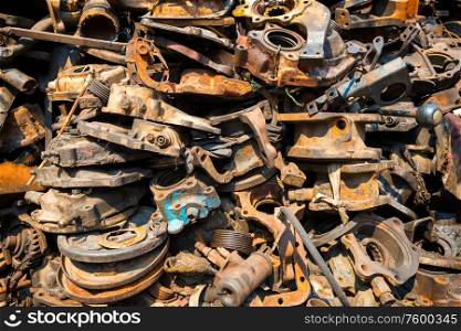 Closeup view of pile of old rusty metal scrap, used machine spares and car parts can be used as mechanic industrial background