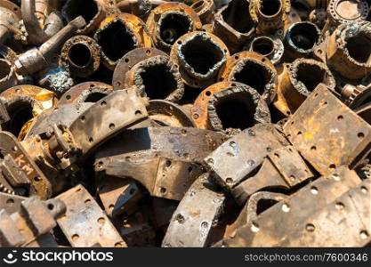 Closeup view of pile of old rusty metal scrap, used machine spares and car parts can be used as mechanic industrial background