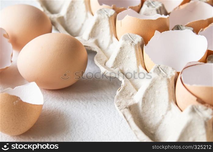 Closeup view of raw chicken eggs in an egg box on white background.