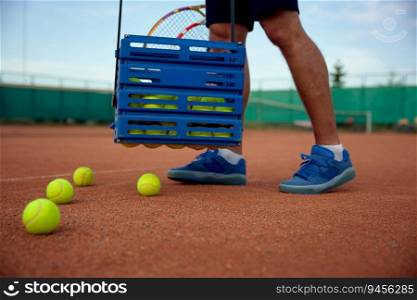 Closeup view of tennis player picking up scattered balls on field after game training. Professional occupation or hobby recreation concept. Closeup view of tennis player picking up scattered balls on field