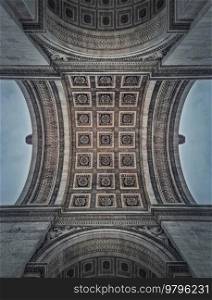 Closeup view underneath triumphal Arch, in Paris, France. Architectural details and ceiling ornate pattern of the famous Arc de triomphe landmark 
