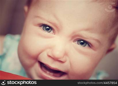 Closeup vintage style portrait of a crying baby, very sad cute little child, bad mood facial expression, whining behavior, unhappy childhood concept