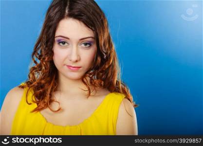 Closeup woman face, girl with long brown curly hair colorful makeup portrait on blue