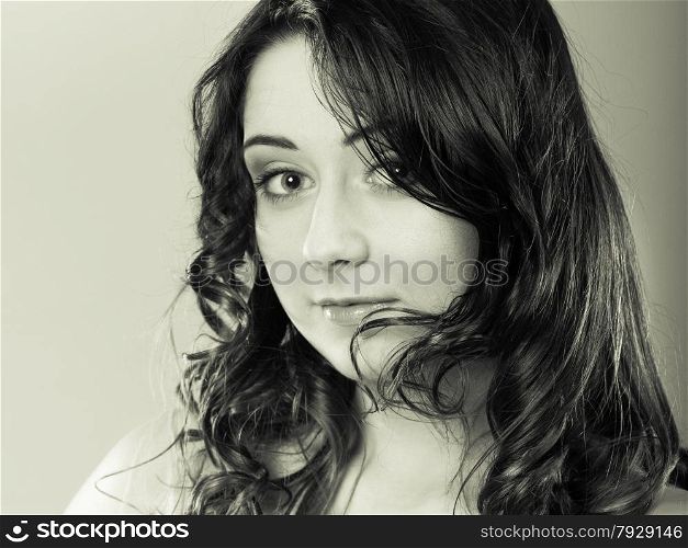 Closeup woman face, girl with long brown curly hair portrait black and white photo