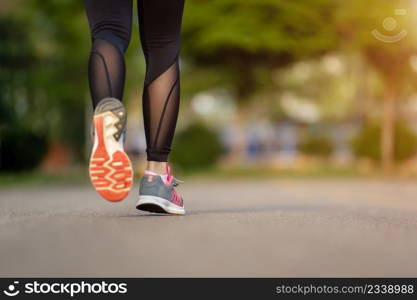 closeup woman feet running on road in the park