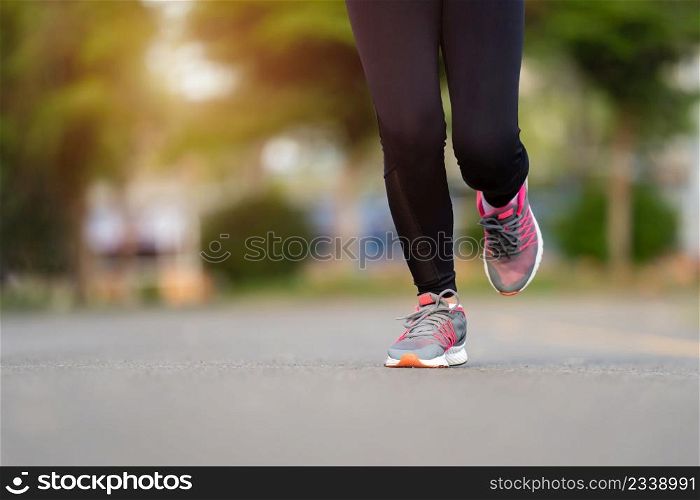 closeup woman feet running on road in the park