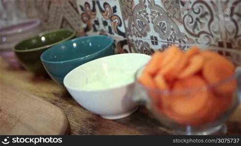 Closeup woman putting chopped onion in ceramic bowl .Young woman cooking healthy meal in the kitchen