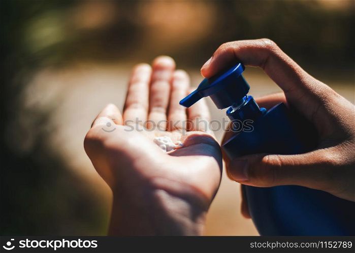 closeup woman putting sunscreen on hand