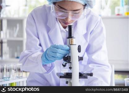 Closeup Woman scientist hand use dropper in lab look at science microscope medical test, research biology chemistry. Females technician laboratory analyzing blood scientific pharmaceutical research.