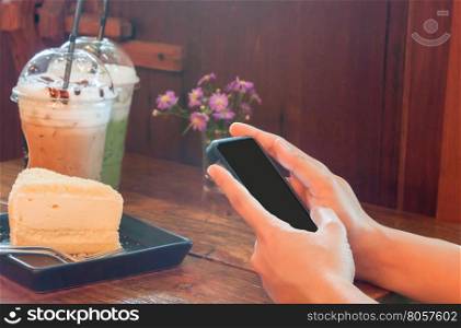 Closeup woman using smartphone in coffee shop, stock photo