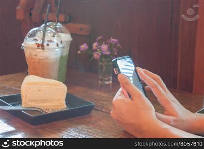 Closeup woman using smartphone in coffee shop, stock photo