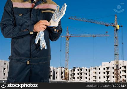 Closeup worker with gloves over building background