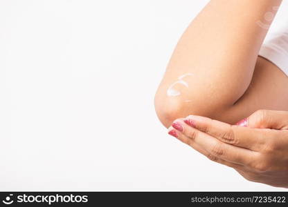 Closeup young Asian woman applies lotion cream on her elbow, studio shot isolated on white background, Healthcare medical and hygiene skin body care concept