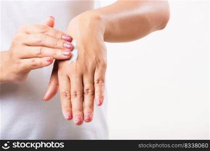 Closeup young Asian woman applying lotion cosmetic moisturizer cream on her behind the palm skin hand, studio shot isolated on white background, Healthcare medical and hygiene skin body care concept