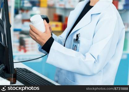 Closeup young pharmacist scanning the barcode of a mockup qualified pharmaceutical, medicine pill container or bottle for copyspace at pharmacy.. Closeup young pharmacist scanning barcode of mockup qualified pill bottle.