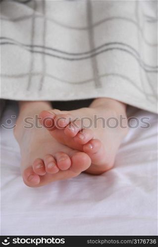 Closup on child&acute;s feet in bed