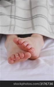 Closup on child&acute;s feet in bed
