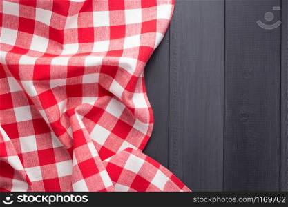 cloth napkin or tablecloth checked at rustic wooden plank board table background, top view