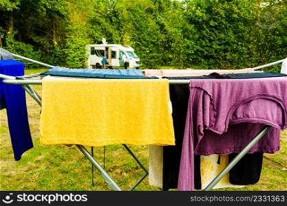 Clothes clean washing laundry hanging to dry on clothesline outdoor, caravan in the background. Camping, adventure concept. Clothes hanging to dry outdoor at caravan