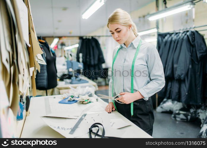 Clothes designer measures a pattern, manufacture on sewing factory. Dress curve measuring, seamstress, dressmaking or tailoring. Clothes designer measures a pattern, sewing