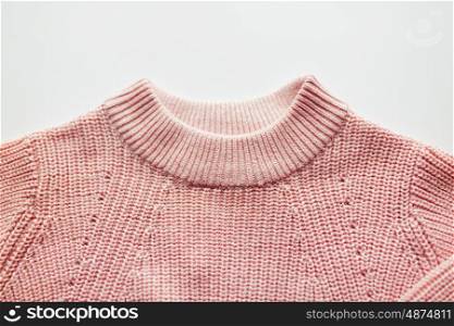 clothes, fashion and objects concept - close up of sweater or pullover on white background