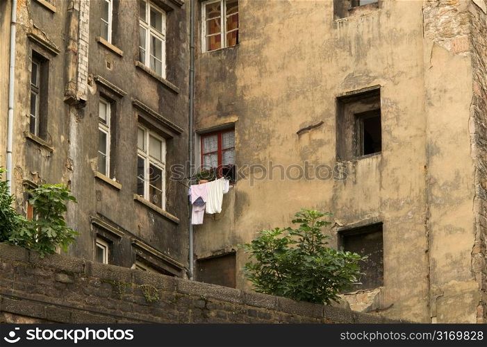 Clothes Hanging From The Window Of A Dilapidated Old Apartment Building