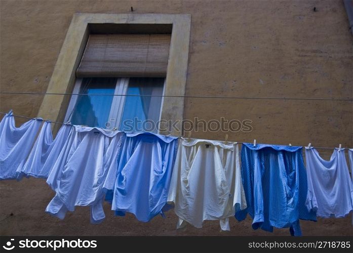clothes hanging underneath a window for drying