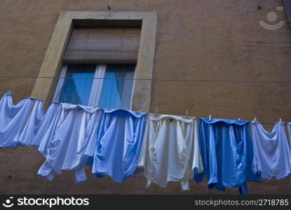 clothes hanging underneath a window for drying