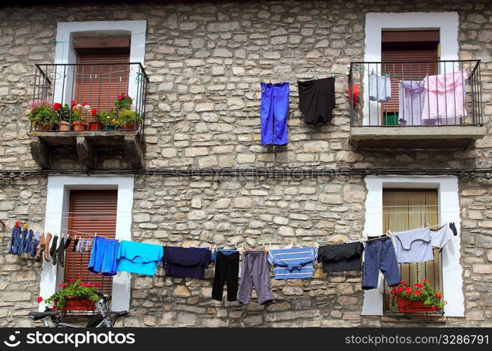 Clothes line hanging from stone wall houses in Spain