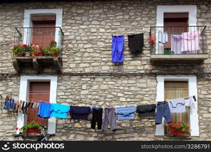 Clothes line hanging from stone wall houses in Spain