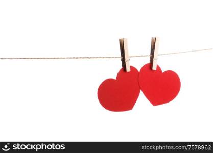 Clothes pegs and two red paper hearts on rope isolated on white background Valentines day concept. Clothes pegs and two red paper hearts