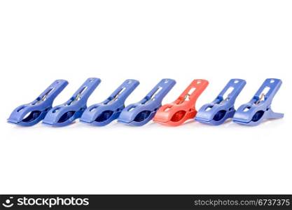 Clothes pegs are in a row. Blue ones and one red