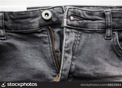 clothes, wear and fashion concept - close up of denim pants or jeans with unfastened zipper