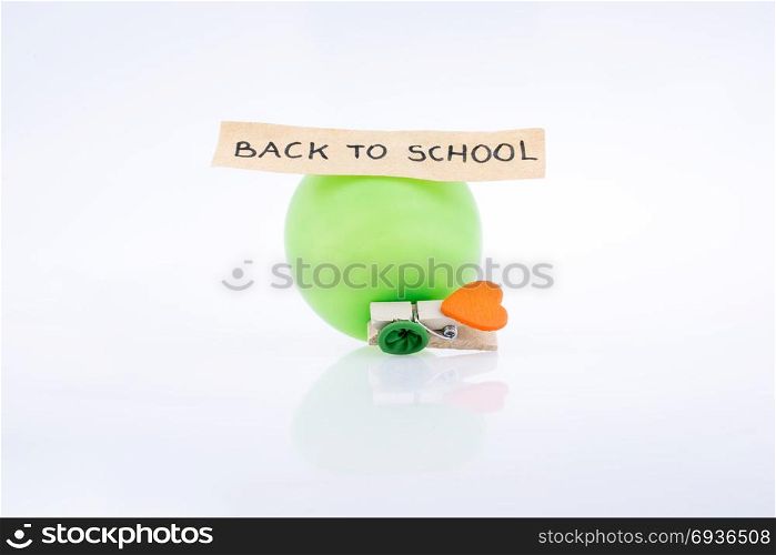 Clothespin with a heart and a balloon on white background