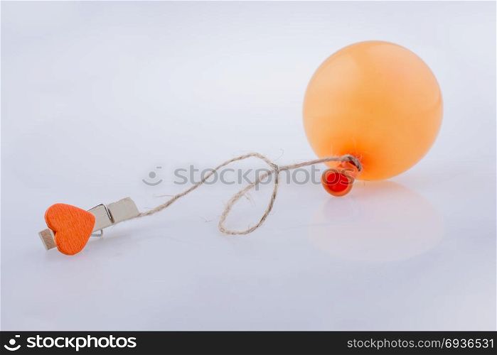 Clothespin with a heart tied to a balloon with a string