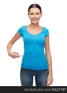 clothing design and gesture concept - smiling girl in blank blue t-shirt pointing her finger at herself