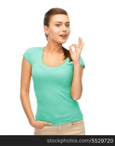 clothing design and happy people concept - smiling girl in blank blue t-shirt showing ok gesture