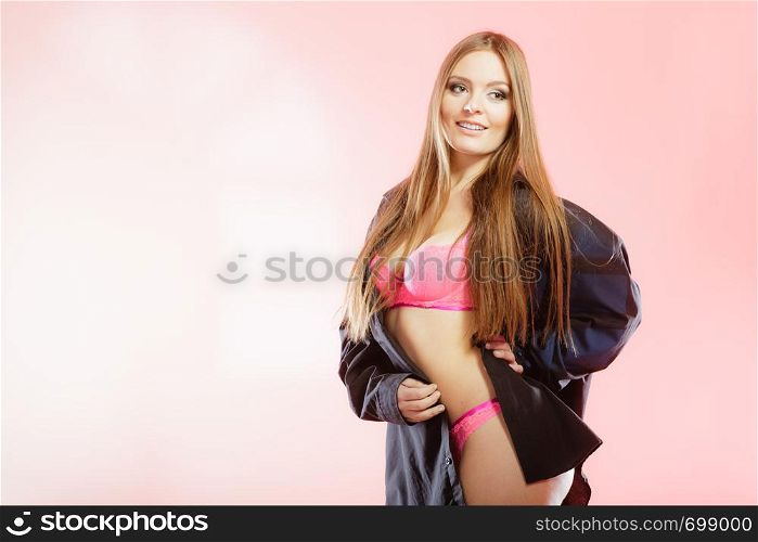 Clothing, fashion, people concept. Attractive woman wearing lingerie. Studio shot of lady with pink underwear and black big shirt.. Attractive woman wearing lingerie.