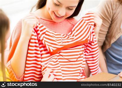 clothing, fashion, style and people concept - close up of happy young women or teenage girls with t-shirt