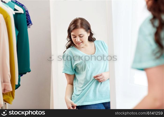 clothing, fashion, style and people concept - happy plus size woman choosing clothes and posing at mirror at home wardrobe
