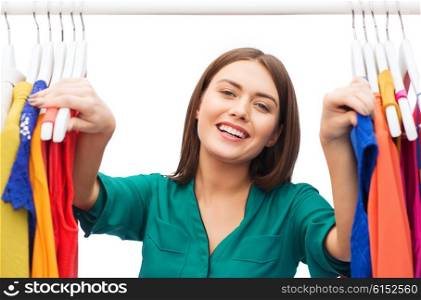 clothing, fashion, style and people concept - happy woman choosing clothes at home wardrobe