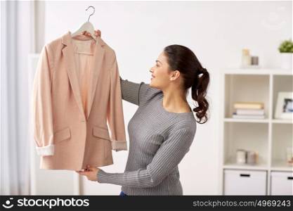 clothing, fashion, style and people concept - happy woman with jacket at home. happy woman with jacket at home