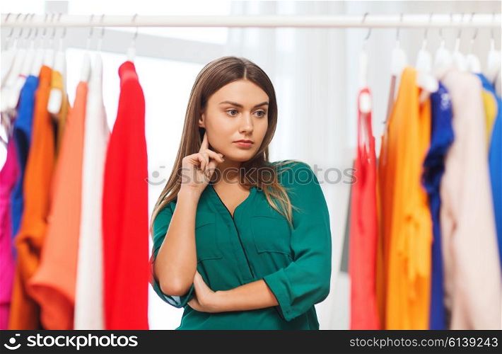 clothing, fashion, style and people concept - woman choosing clothes at home wardrobe