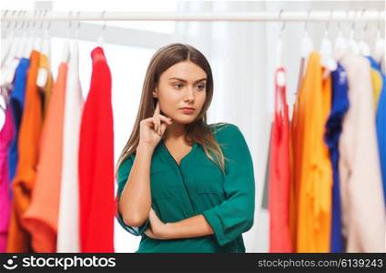 clothing, fashion, style and people concept - woman choosing clothes at home wardrobe
