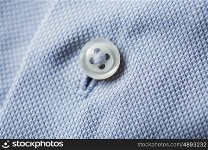 clothing, formal wear, fashion and objects concept - close up of blue shirt button