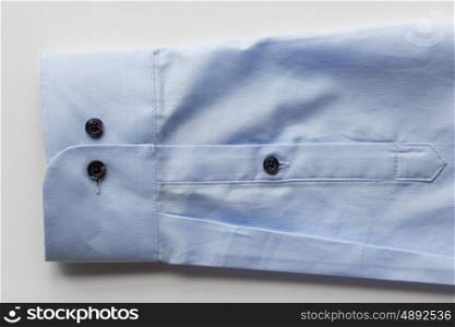 clothing, formal wear, fashion and objects concept - close up of blue shirt sleeve