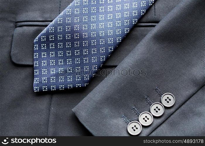 clothing, formal wear, fashion and objects concept - close up of business suit jacket and tie