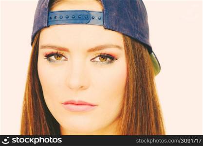 Clothing people concept. Hipster girl with cap. Good looking young lady with beautiful colourful make up.. Hipster girl with cap.